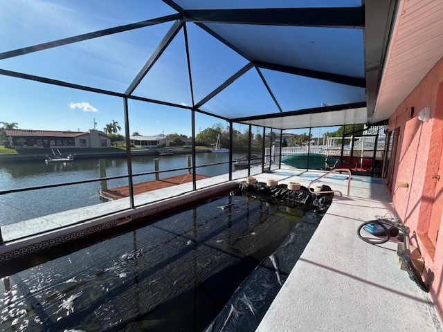 Pool cage under construction over concrete decking in St. Petersburg
