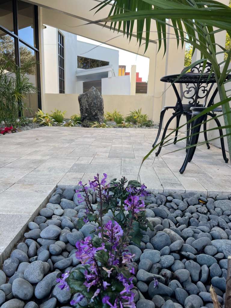 Decorative patio with stone river rocks, pavers, and café seating in Clearwater