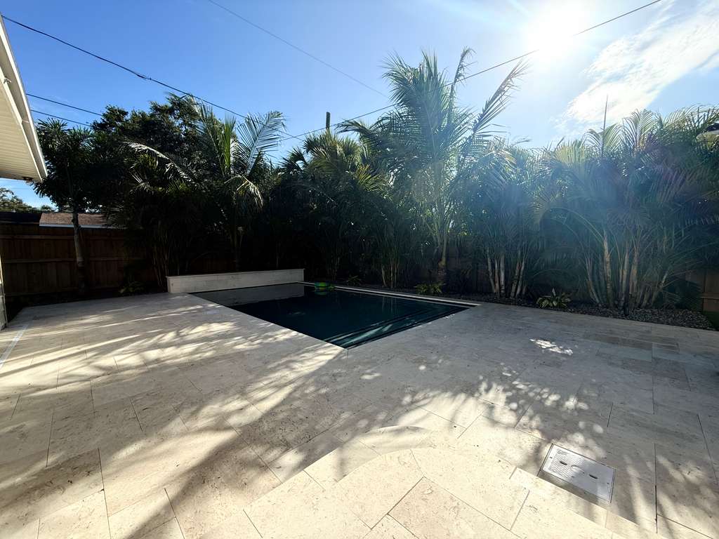 Backyard pool beside white home and fenced border in Clearwater Beach