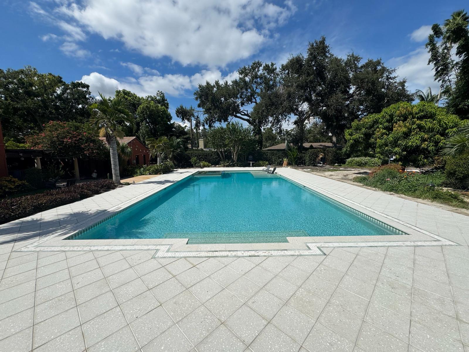 Midday view of classic pool renovation project with new pavers in Tampa