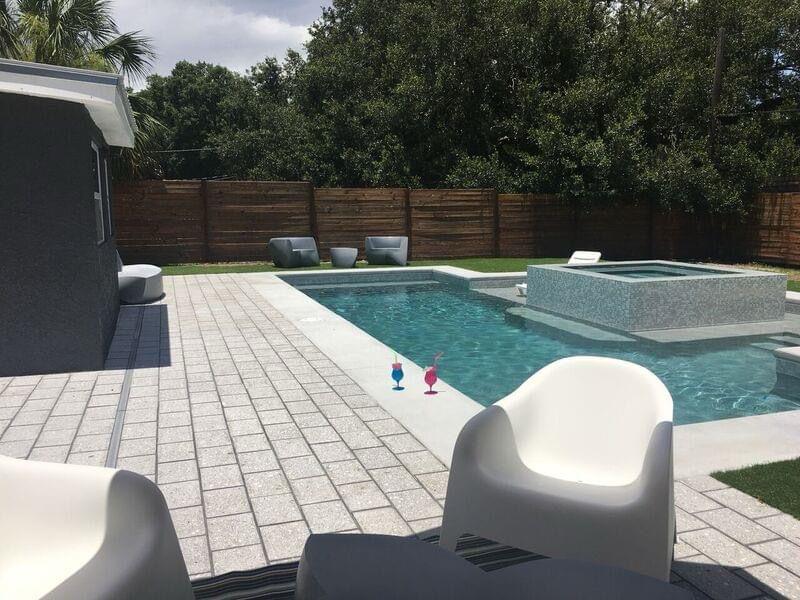 Custom pool and hot tub combo with loungers and turf in St. Petersburg
