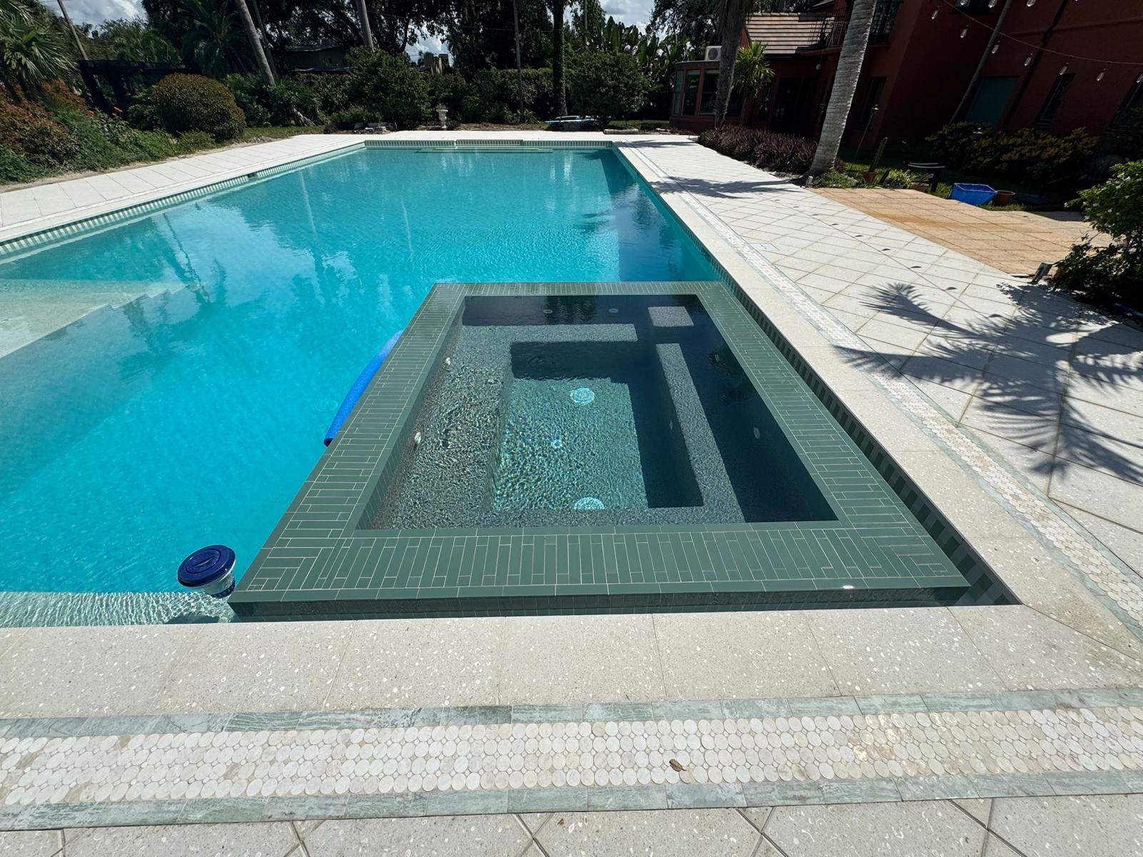 Raised spa with dark tile inside custom-built pool in St. Petersburg