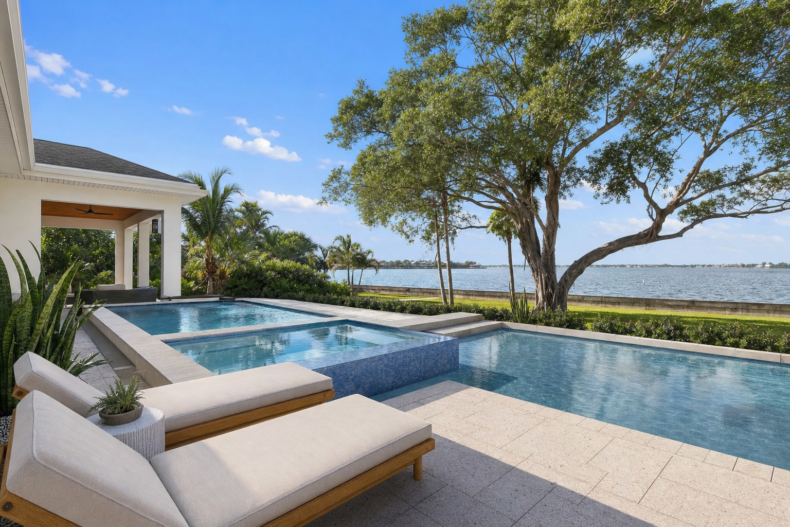 Waterfront Clearwater backyard with a modern pool and spillover spa